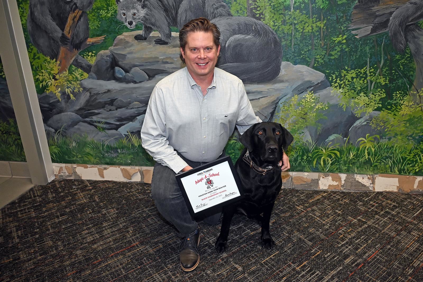 James Rowlett, Houston Home Team Realty team leader, poses with Lenny, Black Elementary School’s comfort dog.